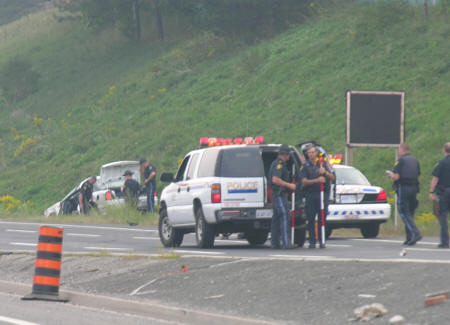 police investigating car roll over crash on highway